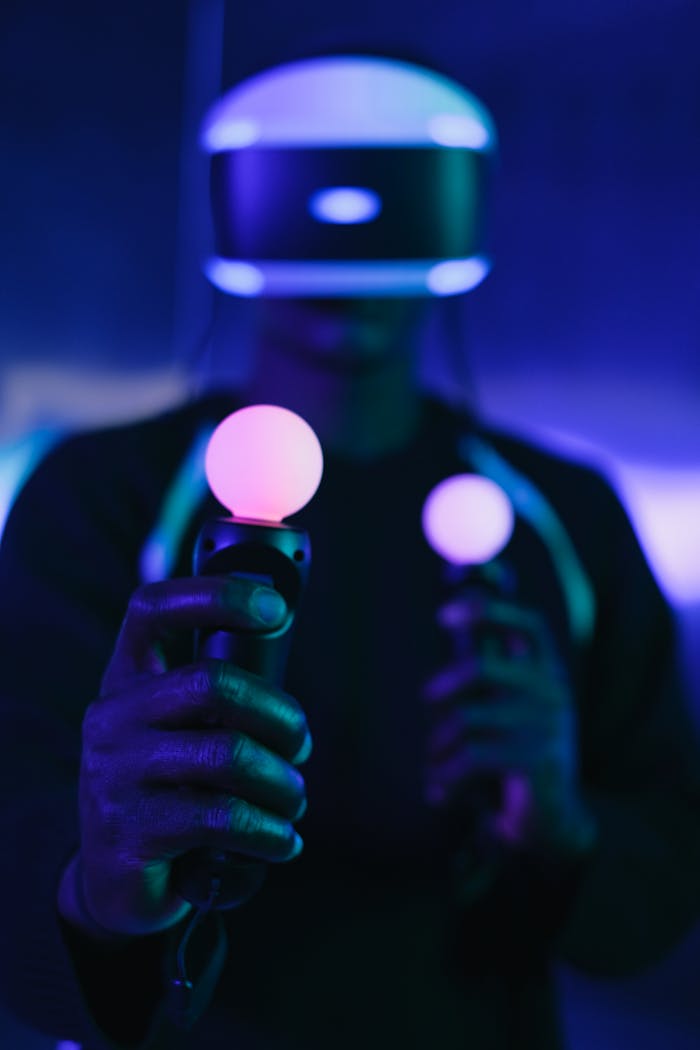 Man using illuminated VR headset and controllers in a modern setting.